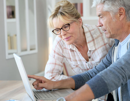 A man and woman are deciding which roofing material to choose online.